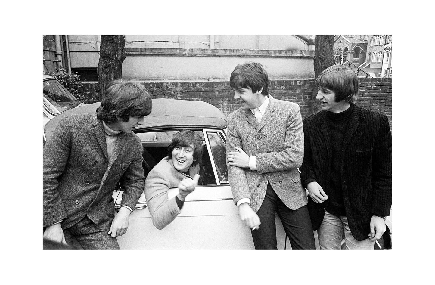 The Beatles - John Lennon with the Band After Passing His Driving Test, England, 1965 Print (1/2)